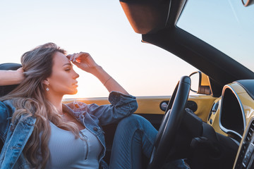The beautiful woman travels by a cabriolet