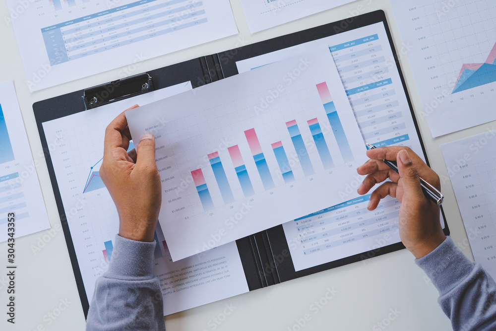 Wall mural businessman working calculate data document graph chart report marketing research development planni