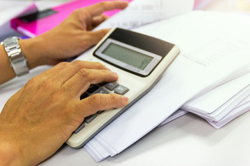 Employees use office calculators with documents of income, expenses, concept of life at work.