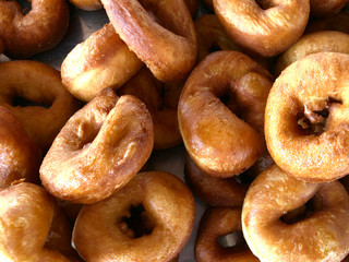 Food background. Many freshly baked round donuts. Horizontal, close-up, cropped shot, top view. Food concept.