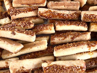 Food background. Many freshly baked cookies with sesame seeds. Horizontal, close-up, cropped shot, top view. Food concept.