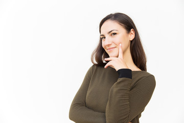 Positive confident Latin woman touching chin, looking at camera, posing. Young woman in casual standing isolated over white background. Pretty woman portrait concept