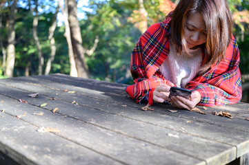 公園でスマホをみてうつむく女性