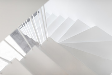 Modern minimalistic metal staircase painted in white with vertical railing, close-up view
