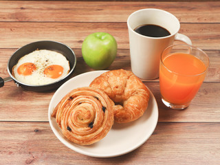 Front view of breakfas set on wooden background.