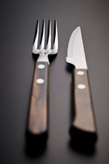 Table fork and knife on black background