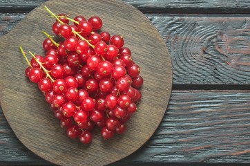 Red fruit in the kitchen. Red currant on a brown wooden table.