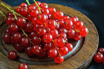 Red fruit in the kitchen. Red currant on a dark fabric background.
