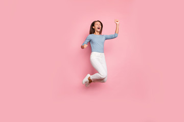 Fototapeta na wymiar Full length body size turned photo of cheerful overjoyed crazy excited girl expressing overjoyed emotions jumping on face in trousers isolated pastel color background