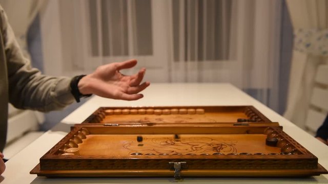 Beginning of a backgammon game with a player who throw dices on board