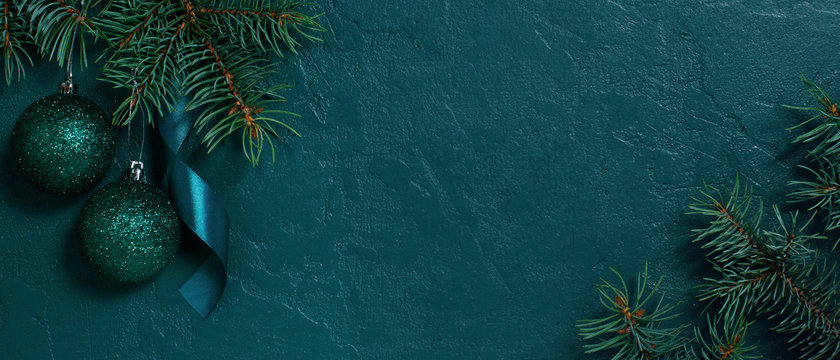 Fir branches and Christmas or New Year banner on the textured dark emerald background