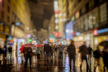 Crowd of anonymous people walking on busy night streets.rainy night in vienna 