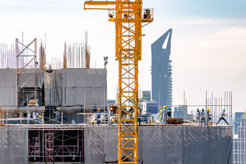 Aerial view of a building construction site in progress with tower crane, scaffolding, formwork,...