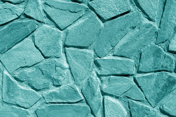 Wall made of old stones in cyan tone.