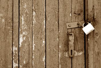 Grungy wooden door with lock in brown tone.