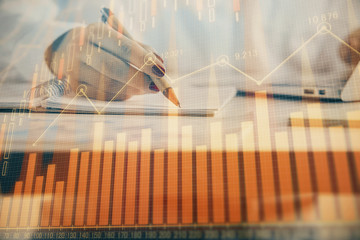 Double exposure of woman's hands making notes with forex graph hologram. Concept technical analysis.