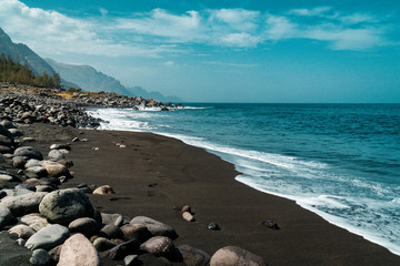 Fototapeta na wymiar View of the black beach Playa de Guayedra with volcanic boulders in Las Palmas on Gran Canaria volcanic island, Spain, Atlantic ocean