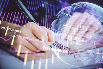 Forex graph on hand taking notes background. Concept of research. Double exposure