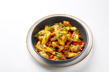 Baby Corn Manchurian dry looks like Schezwan Baby Corn isolated at white background. Baby Corn Manchurian - is indo chinese cuisine dish with deep fried corn, bell peppers, sauce and onion.