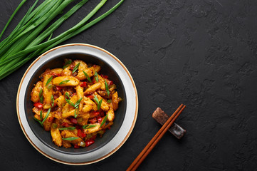 Baby Corn Manchurian dry looks like Schezwan Baby Corn in black bowl at dark slate background. Baby Corn Manchurian - is indo chinese cuisine dish with deep fried corn, bell peppers, sauce and onion.