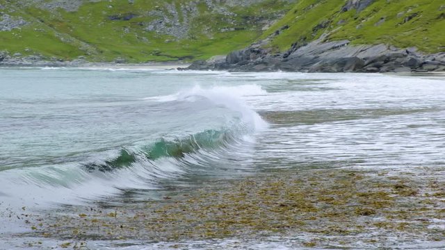 waves on the beach among the mountains in norway lofoten