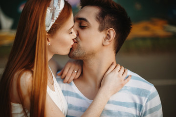 Fototapeta premium Side view portrait of a beautiful young couple kissing outdoor while dating.