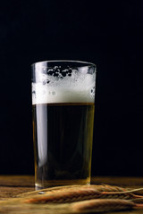 Beer in a glass on a wooden table on a dark background