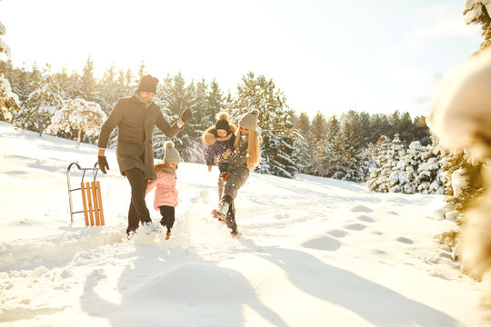 Playful couple with kids in winter woods