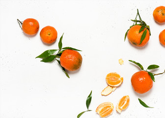 Christmas fruit. Orange fresh tangerines or mandarines with green leaves on a white stone background. Harvest and health food concept. Top view.