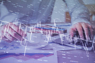 Forex graph with businessman working on computer in office on background. Concept of hardworking. Double exposure.