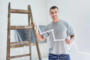 Man with folding rule and ladder as a handyman