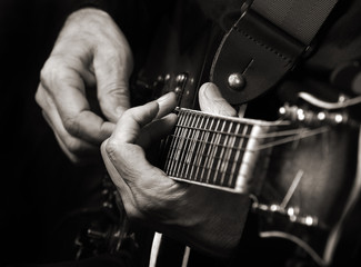 Guitarist hands and guitar close up. playing electric guitar black and white.
