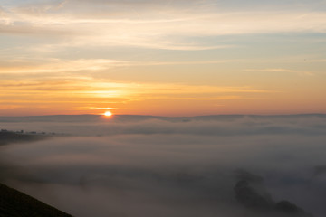 Sonnenaufgang in den Weinbergen über dem herbstlichen Main im Nebel