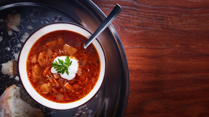 Ukrainian traditional borsch. Russian vegetarian red soup in white bowl on black background.