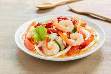 close up of spicy shrimps salad in a ceramic dish on wooden table. delicious thai style food menu.