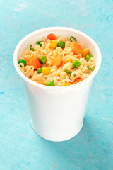 Ramen cup, instant soba noodles in a plastic cup with vegetables close-up