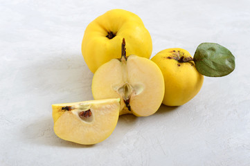 Ripe quince on a light background. Whole and sliced fruits.