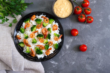 Rice with broccoli, shrimps and cream cheese sauce. Healthy and tasty food. Proper nutrition. Sports diet. Top view.