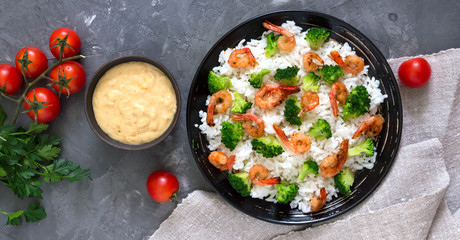 Rice with broccoli, shrimps and cream cheese sauce. Healthy and tasty food. Proper nutrition. Sports diet. Top view.