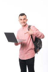 Photo of young guy, smiling at camera while holding and pointing at laptop, standing over white background