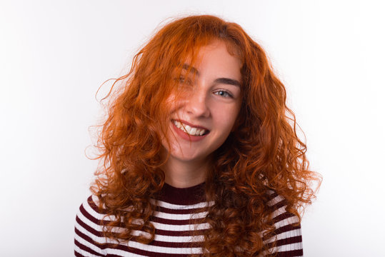 Photo of cute curly red head young woman, smiling at camera, over whote background