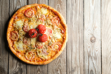 Traditional italian pizza with tomatoes, cheese, ham, mushrooms and arugula on a light rustic background top view copy space. .
