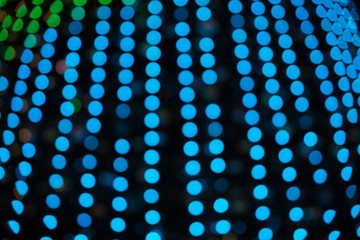 Texture of abstract blue bokeh from the lights of a Christmas tree on a dark background.