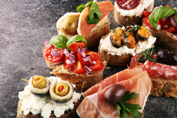 Appetizers table with italian antipasti snacks and wine in glasses. Brushetta or authentic traditional spanish tapas set, cheese variety