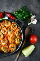 .Stuffed peppers with rice, meat and spices in a dark pan on a dark background top view