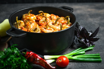.Stuffed peppers with rice, meat and spices in a dark pan on a dark background..