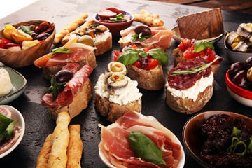 Appetizers table with italian antipasti snacks and wine in glasses. Brushetta or authentic traditional spanish tapas set, cheese variety