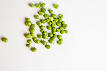 Green fresh scattered peas on a white background.