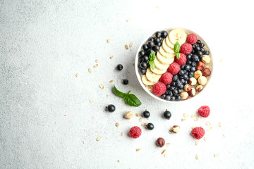 Healthy breakfast. Oatmeal with berries and fruits on a light background top view copy space.