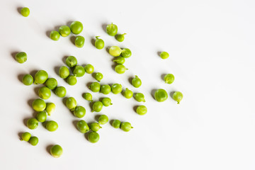 Green fresh scattered peas on a white background.